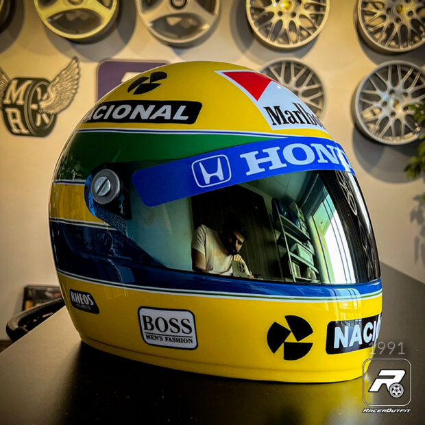 O Capacete Tributo Ayrton Senna é uma obra de arte que transcende sua função como item de uso e se transforma em uma peça de decoração exclusiva. Inspirado pelo Grande Prêmio de 1991 e pelo lendário piloto Ayrton Senna, este capacete é uma celebração da paixão pelo automobilismo, da busca incessante pela excelência e do compromisso com a segurança nas pistas.